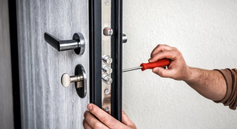 Image d'une personne installant une serrure sécurisée sur une porte d'entrée.